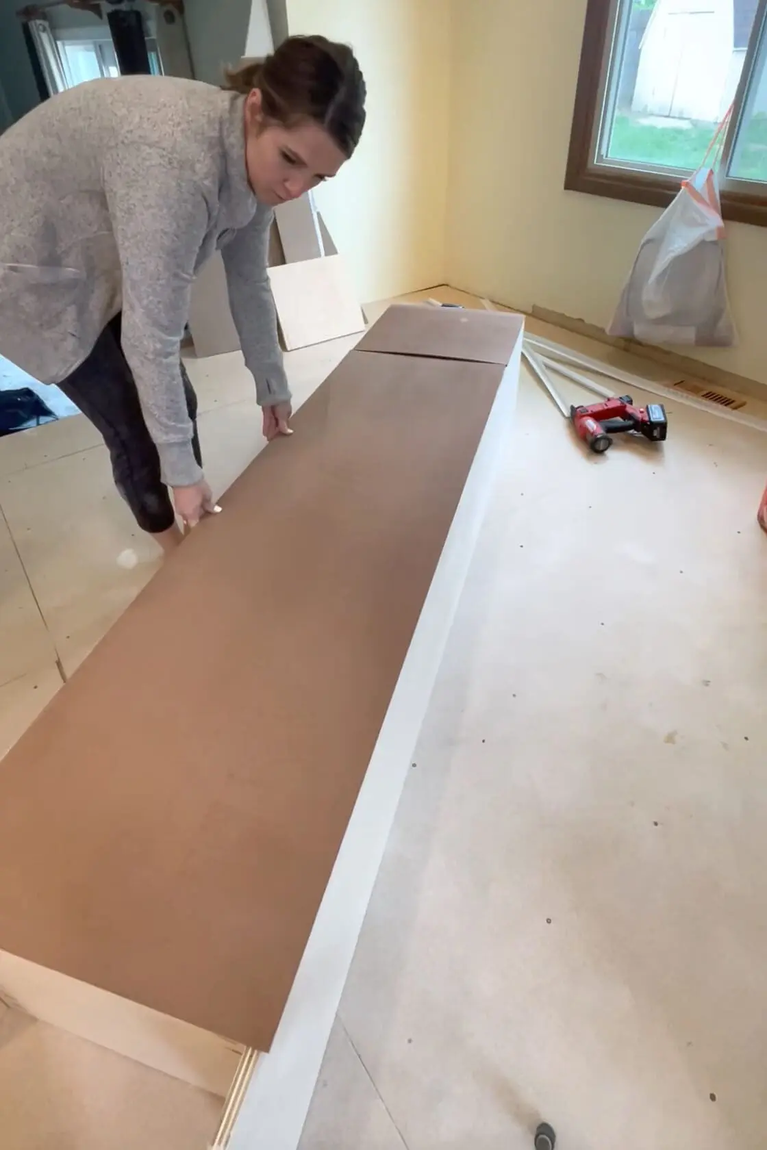 Adding backing to DIY pantry shelves.